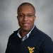Portrait of a man with glasses and a wvu shirt.